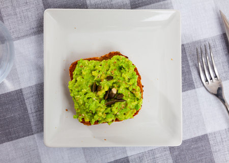 Sandwich with guacamole butter and seeds on whole grain bread, healthy eating concept