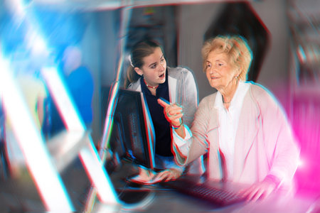 Senior woman and her granddaughter using computer in escape roomの写真素材