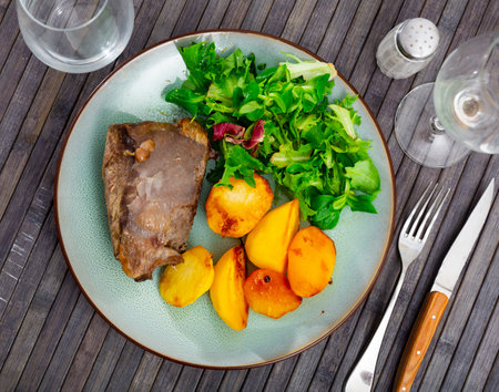 Roasted veal with potatoes fries on a ceramic plate cooked in cafeの写真素材