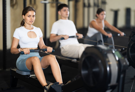 Young woman training her arms on machine