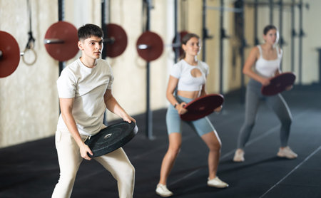 Young guy training with weight plate
