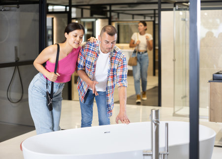 Married couple discussing bathtub colors in hardware storeの写真素材