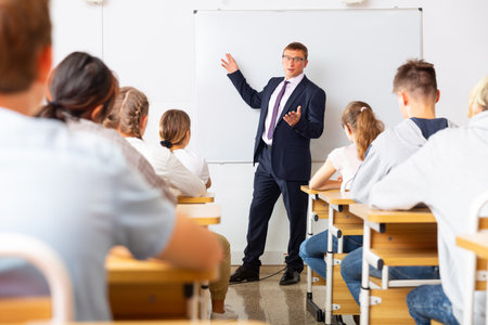 Adult teacher is giving lecture for students in classの写真素材
