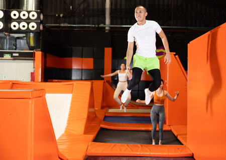 Male athlete training to jump on trampolines at trampoline centerの写真素材