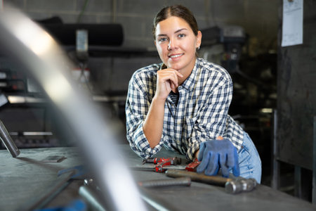 Young woman posing in metallurgical workshopの写真素材