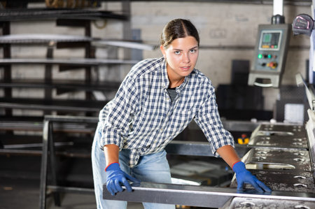Young woman cuts profile pipe on machine