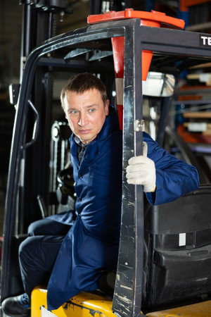Experienced forklift driver transporting iron sheets inside metallurgical plant