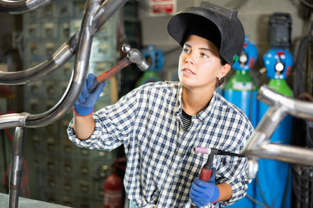 Young woman working with welding machineの写真素材