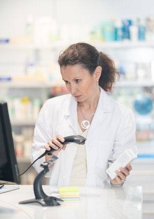 Portrait of friendly female pharmacist at the cash register in pharmacyの写真素材