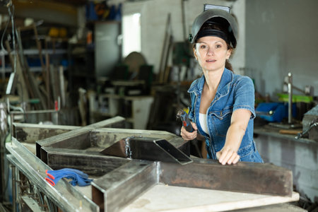 Adult female welder posing in workshop