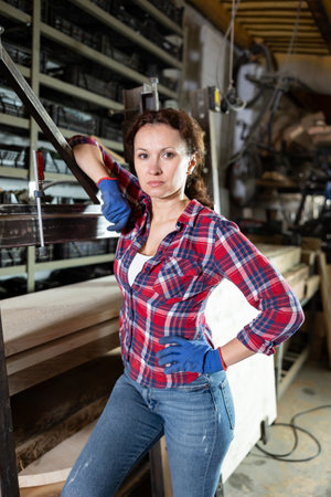 Preparing metal structures - woman secures metal profile with clampの写真素材