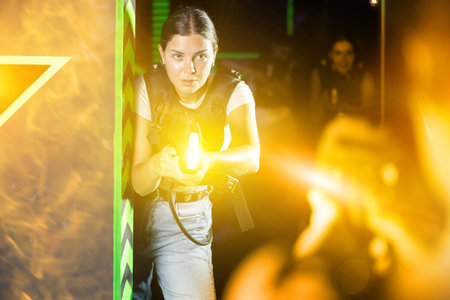 Girls play laser tag, jokingly fight with light weaponsの写真素材