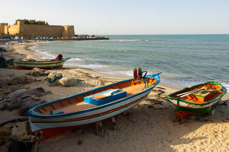 Fishing boats on beach near Hammamet Kasbah, Tunisiaの写真素材