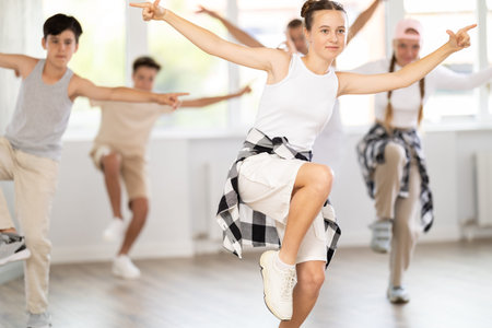 Teen girl with group of teenage friends, learn to dance hip hop