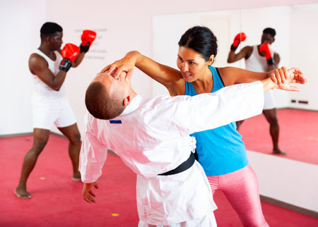 Men and woman training self-protection martial arts in gymの写真素材