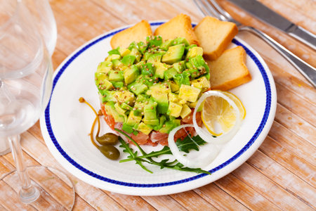 Delicious salmon tartare with avocado, arugulaの写真素材