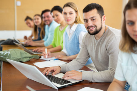 Adult students listening task for exam in classroom
