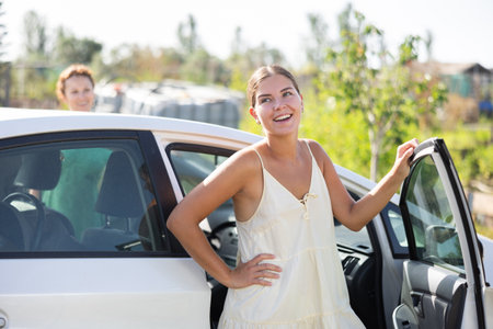 Portrait of smiling girl about to get into her carの写真素材