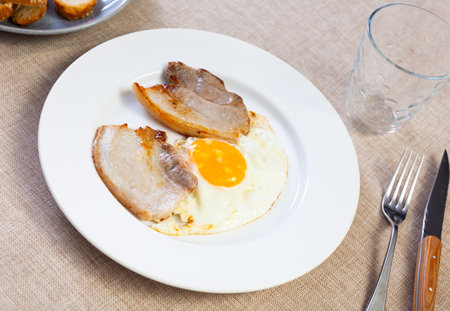 Fried sunny side up egg with crispy pancetta slicesの写真素材
