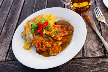 Chicken fillet served with baked potatoの写真素材