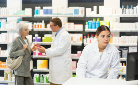 Female pharmacist in medical uniform posing while working in pharmacyの写真素材