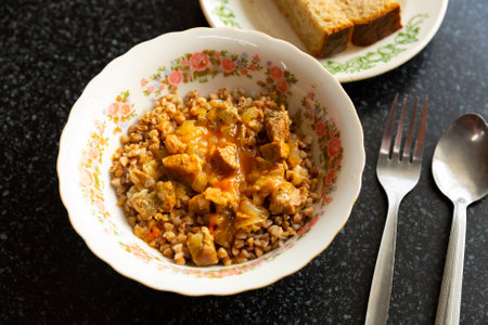 Boiled buckwheat with goulash served with bread in canteenの写真素材