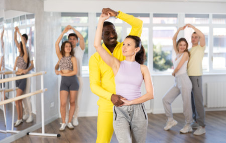 African American practicing bachata with brunette in dance class