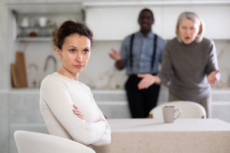 Adult man and elderly woman quarreling with womanの写真素材