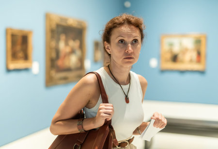 Woman viewing art gallery with brochure