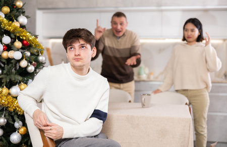 Adult man and young woman quarreling with young guyの写真素材