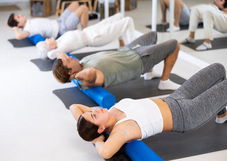Group of different people doing exercises with rollerの写真素材