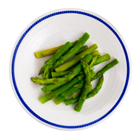 Fresh green asparagus with sunflower oil on white plateの写真素材