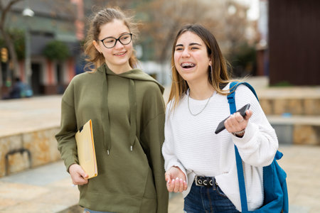 Smiling teenage girls walking after lessonsの写真素材