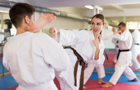 Young woman in kimono practicing kicking paired with male partnerの写真素材