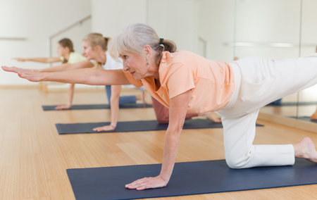 Senior woman practicing yoga in studioの写真素材