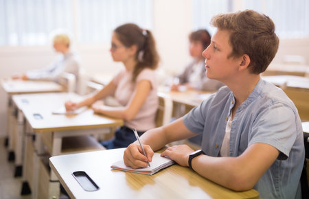 Diligent teenage high school student studying with classmatesの写真素材