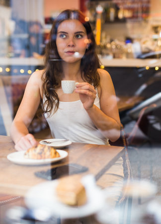 Portrait of young woman drinking coffee in cafeの写真素材