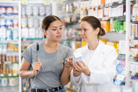 In cosmetic department of pharmacy, buyer asks consultant to help and choose cleansing gel.の写真素材