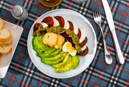 Caprese salad served with avocado and eggs