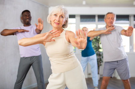 Senior woman practicing hip-hop during group dance classの写真素材