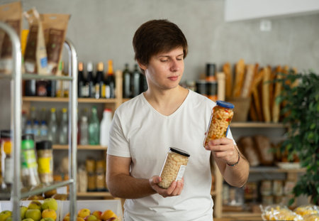 Young man choosing beans in grocery store