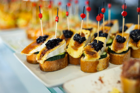Spanish tapas - pinchas with goat cheese, cucumber and white breadの写真素材