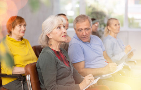 Group of older students sitting and listening at lessonの写真素材