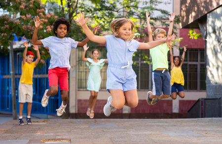 Happy multiracial boys and girls jumping outdoorsの写真素材