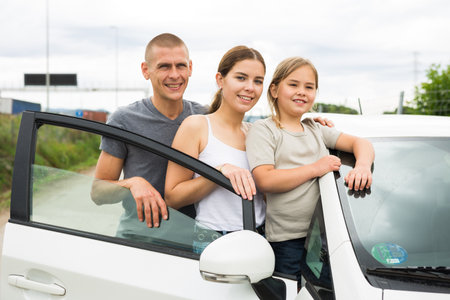 Portrait of happy family near their new carの写真素材
