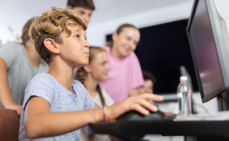 Boy student learning to work on computer in classroom