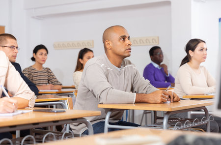 Group of students attentively listening to lecture in classroomの写真素材