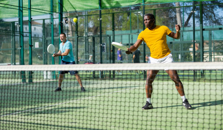 African american man padel tennis player trains on the courtの写真素材