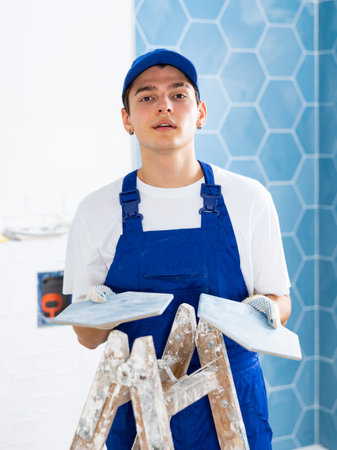 Young tiler working with ceramic tiles for interior decoration of repairable roomの写真素材