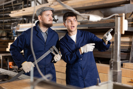 Foreman gives instructions to worker at furniture factory